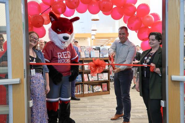 library services staff ribbon-cutting ceremony with Mascot