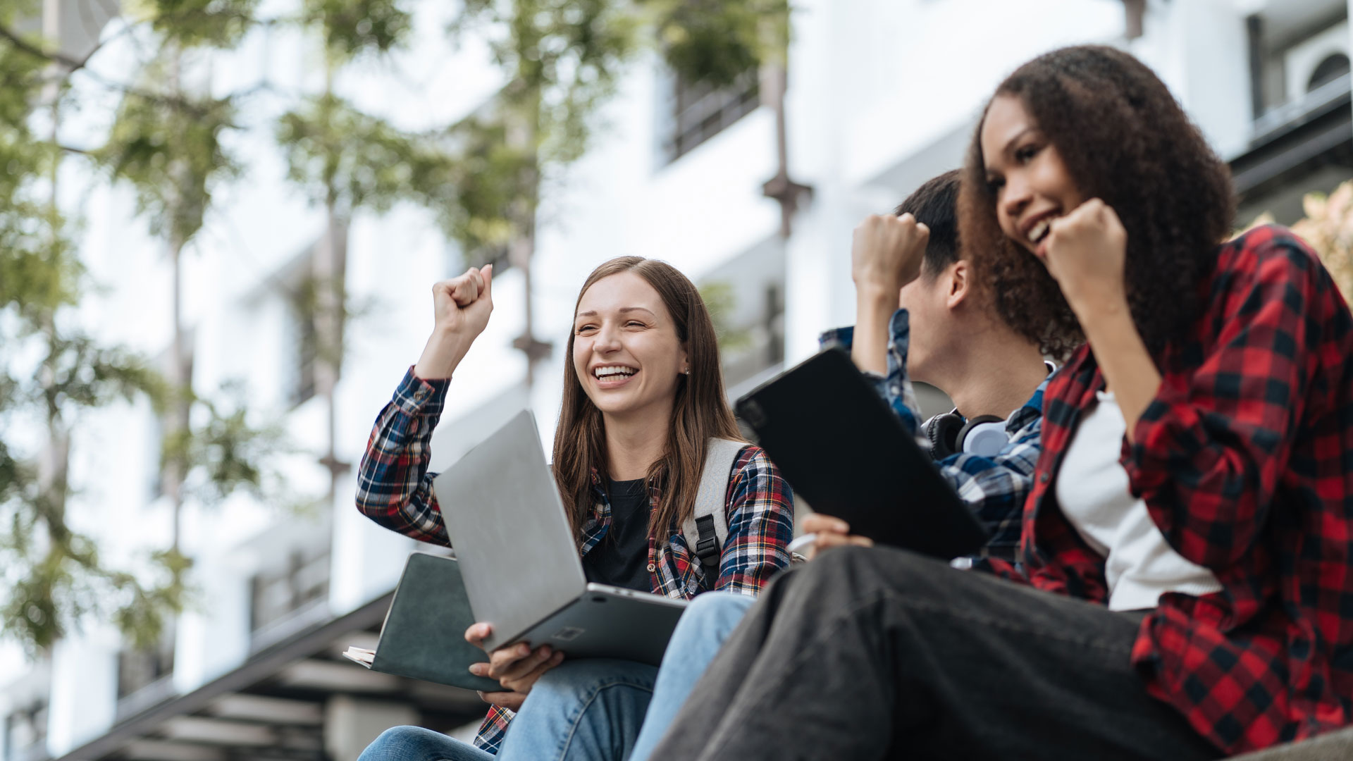 Students sitting outside using laptops