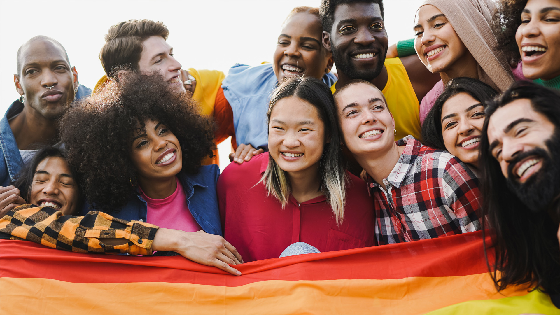 Group of student gathered around a pride flag