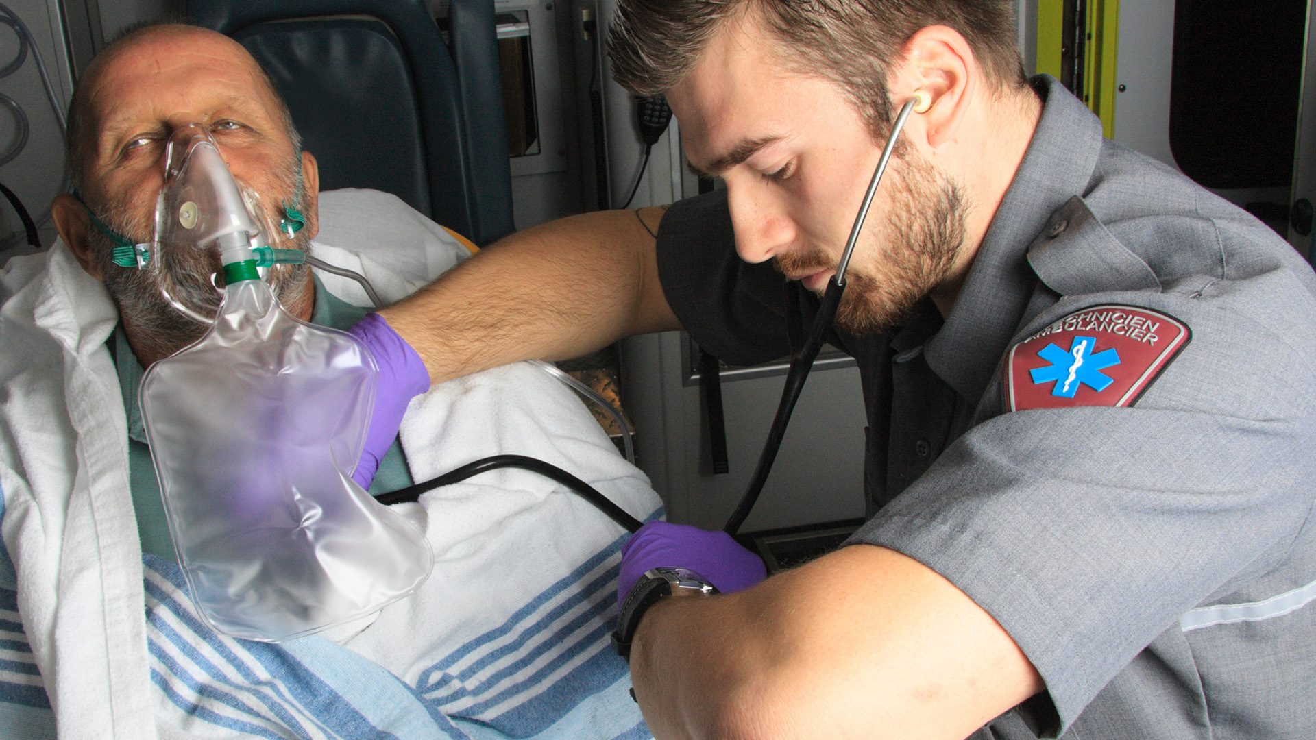 EMT checking patients pulse in ambulance