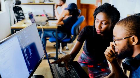 Two people looking at a computer