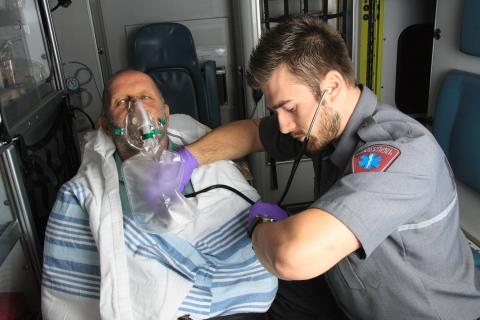 man checking pulse of patient in ambulance