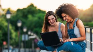 two women using a laptop